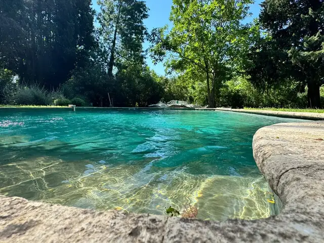 Eau turquoise et margelle en pierre naturelle